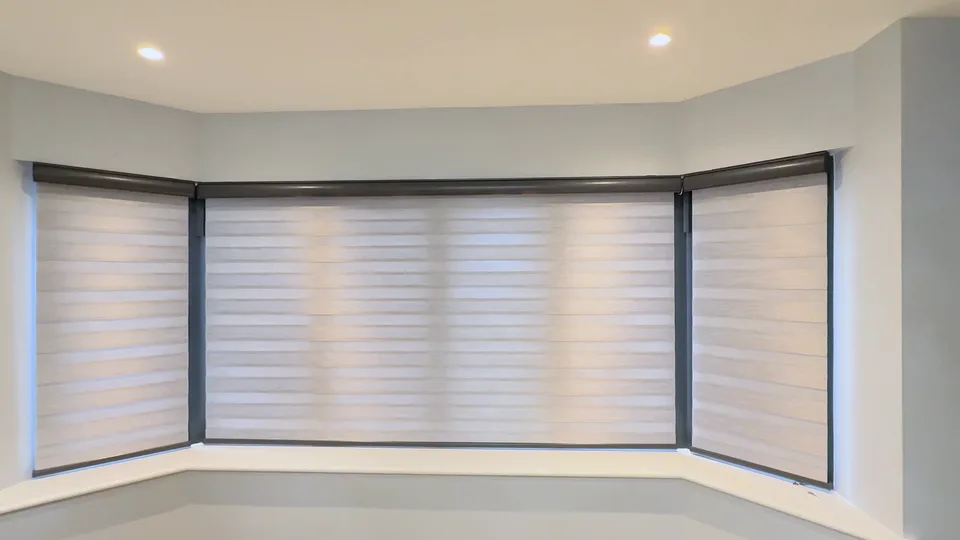 Bay window with the blinds lowered and solid bands overlapped, closing the view.